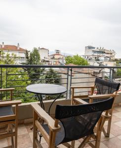 a patio with a table and chairs on a balcony at Central apartment with parking in Larisa