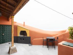 Lomo de Mena的住宿－Lightbooking Casa cueva Las Teresitas Tenerife，一个带桌子和比萨饼烤箱的庭院