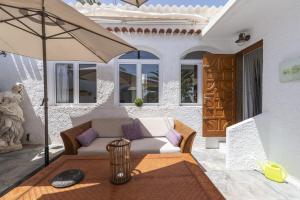 a living room with a couch and an umbrella at Lightbooking Telde Lomo Salas Dey in Telde