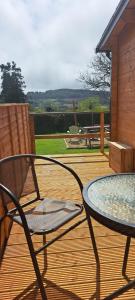 a patio with a table and chairs on a deck at The Stunning Log House in Wexford
