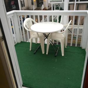 a white table and two chairs on a porch at The New Oceanic Inn in Old Orchard Beach