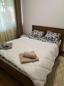 un grande letto con lenzuola e cuscini bianchi di Casa Galina a Bucarest