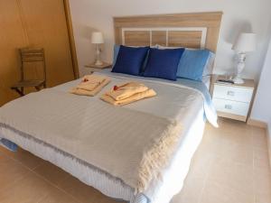 een slaapkamer met een groot bed en handdoeken bij Lightbooking Costa Antigua in Costa de Antigua