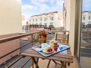 - une table avec un plateau de nourriture sur le balcon dans l'établissement Lightbooking Costa Antigua, à Costa de Antigua