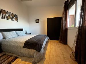 um quarto com uma cama e uma grande janela em Lightbooking Agua Garcia Tacoronte con terraza em Tacoronte