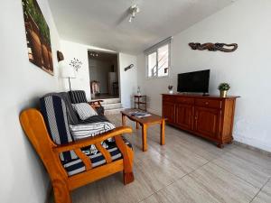 uma sala de estar com uma cadeira e uma televisão em Lightbooking Agua Garcia Tacoronte con terraza em Tacoronte