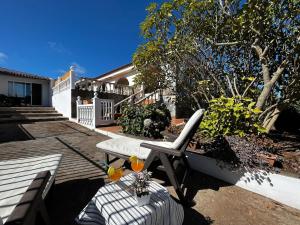 un patio con una silla blanca y una mesa en Lightbooking Agua Garcia Tacoronte con terraza, en Tacoronte