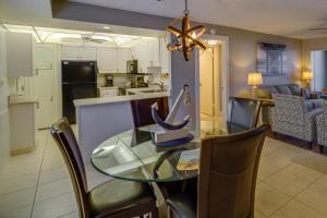 a dining room and kitchen with a glass table and chairs at Sunny Ocean Village Condo with Community Pool! in Fort Pierce