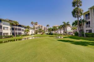 a golf course with palm trees and condos at Sunny Ocean Village Condo with Community Pool! in Fort Pierce