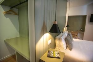 a bedroom with a bed with a table and a lamp at Olive Boutique Guesthouse in Vila Franca do Campo