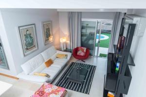 a living room with a white couch and a tv at Lightbooking piscina privada Salobre Golf in San Bartolomé de Tirajana