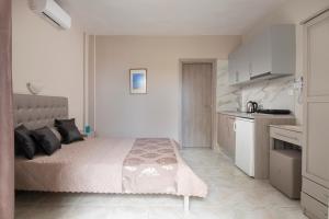 a bedroom with a bed and a small kitchen at casamariatoroni in Toroni