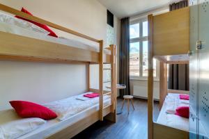 1 Schlafzimmer mit 2 Etagenbetten und einem Fenster in der Unterkunft MEININGER Hotel Berlin Mitte in Berlin
