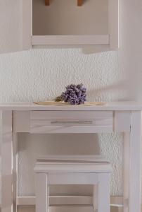 a white table with a plate of flowers on it at casamariatoroni in Toroni