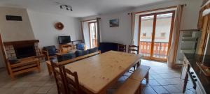 sala de estar con mesa, sillas y TV en La Turra en Lanslebourg-Mont-Cenis