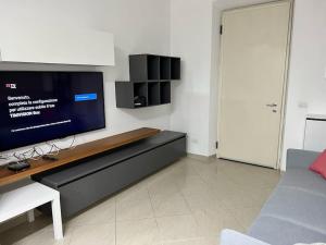 sala de estar con TV y sofá en Casa Maddy Pietrasanta en Pietrasanta