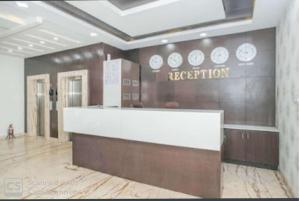 a lobby with a reception desk in a building at Western Keys Hotel in Bangalore