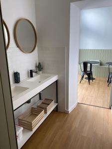 a bathroom with a sink and a mirror and a table at Olive Boutique Guesthouse in Vila Franca do Campo