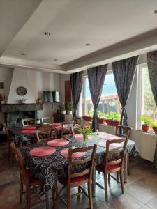 una sala da pranzo con tavolo, sedie e finestre di Mountain View a Buşteni