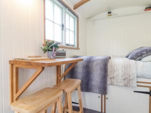 a tiny house with a desk and a bed at Gwithian Shepherds Hut in Hayle