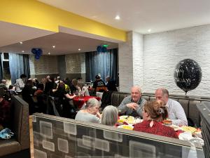 un groupe de personnes assises à une table dans un restaurant dans l'établissement Earl David Hotel, à East Wemyss