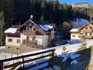 a house in the snow with a fence at Horský apartmán Vrátna-Saška in Terchová +19 photos