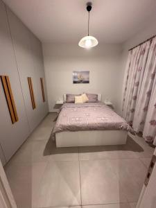a bedroom with a bed and a pendant light at A&A Apartment in Piraeus