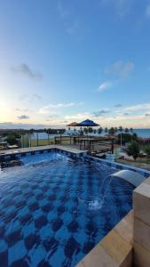 a swimming pool with a view of the ocean at Pousada Bugaendrus in Touros