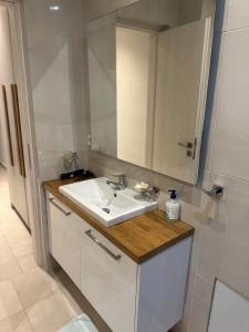 a bathroom with a white sink and a mirror at A&A Apartment in Piraeus