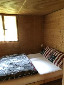 uma cama num chalé de madeira com uma janela em Chata u certovych hlav 3 em Želízy