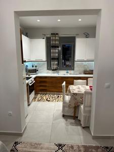a kitchen with white cabinets and a table with chairs at A&A Apartment in Piraeus