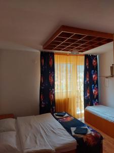 a small bedroom with a bed and a window at Mountain View in Buşteni