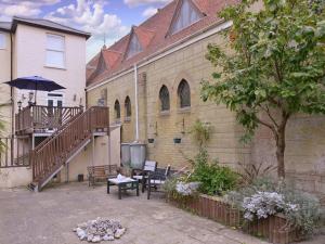 un edificio con un patio con una mesa y una sombrilla en Pier Top - Free all Island parking permit, en Ventnor