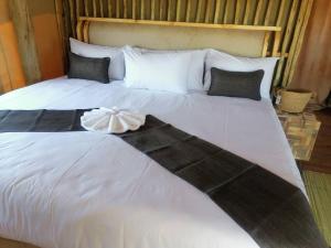 a large white bed with a dress on it at Xhabe Safari Lodge Chobe in Muchenje