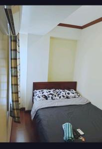 a bedroom with a bed with a black and white comforter at Isabelle Garden Villas 509 in Manila