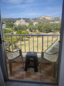 een balkon met 2 stoelen en een tafel bij Paradise in Kefalos