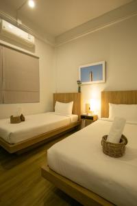 Ban Laem Muang的住宿－Sirichai Design Hotel，客房设有两张床和窗户。