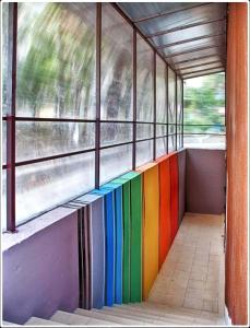 ein Zugzimmer mit einer Regenbogenwand und Fenstern in der Unterkunft Sweet Home in Dnipro