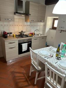 une cuisine avec une table avec deux chaises et une cuisinière dans l'établissement La Casa di Laura, à Cortone