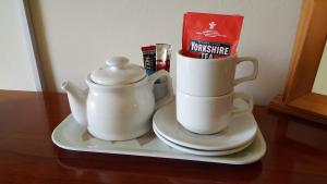 um bule de chá e uma chaleira num prato em The Wood Cottage em Scarborough
