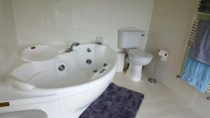 a bathroom with a white tub and a toilet at The Wood Cottage in Scarborough