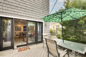 a patio with a table and an umbrella on a deck at San Diego Home with Deck Walk to Mission Beach! in San Diego