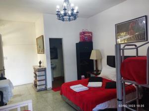 um quarto com uma cama com um cobertor vermelho em hostel olivos em Olivos