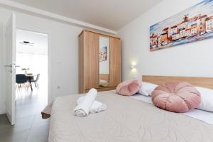 sypialnia z 2 różowymi poduszkami na łóżku w obiekcie Apartment Vuletin w mieście Kaštela