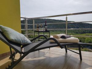 a chair sitting on a balcony with a view at Villa Leca with heated private pool & sauna in Bribir