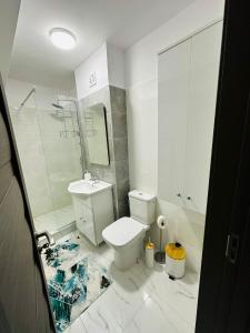 ein weißes Bad mit einem WC und einem Waschbecken in der Unterkunft B&S Boutique Studio in Mamaia Nord – Năvodari