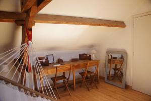 a room with a wooden desk with chairs and a mirror at La Vigie in Couëron