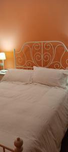 a large white bed with a metal headboard and pillows at As pitas in Tapia de Casariego