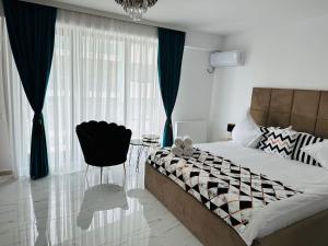 ein Schlafzimmer mit einem Bett und einem Stuhl neben einem Fenster in der Unterkunft B&S Boutique Studio in Mamaia Nord – Năvodari
