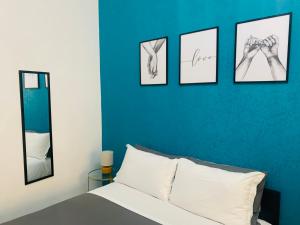 ein Schlafzimmer mit vier Bildern von Händen an einer blauen Wand in der Unterkunft SAN MARCO 13 l t in Neapel